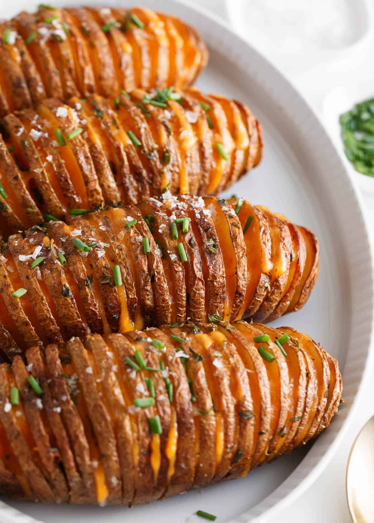 Hasselback potatoes on a white plate.