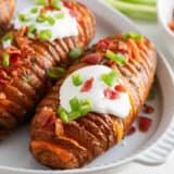 Hasselback potatoes with sour cream on top.