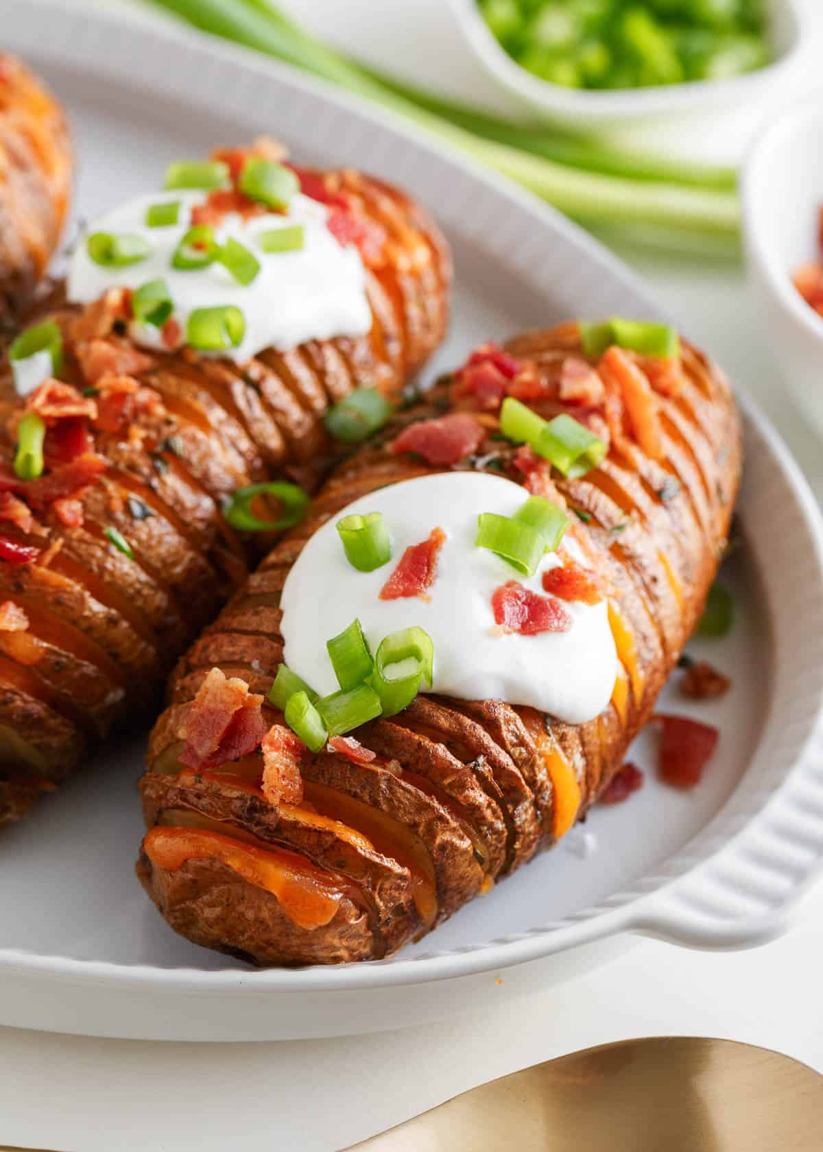 Hasselback potatoes with sour cream on top.