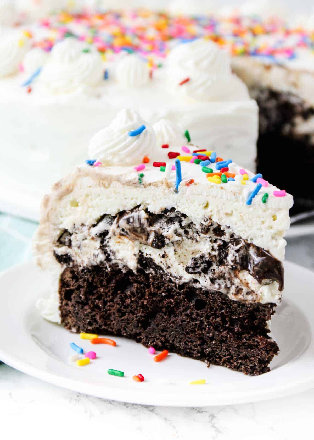 A slice of ice cream cake with sprinkles on top. 