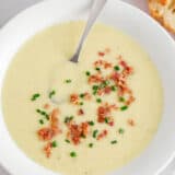 Potato leek soup in a bowl with bread.