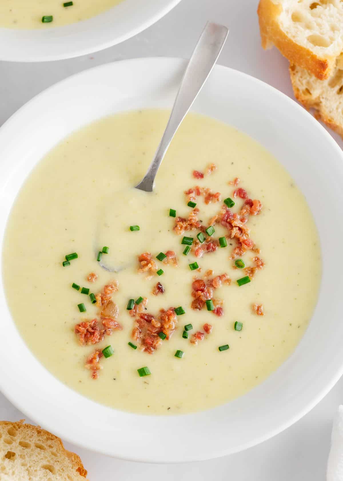 Potato leek soup in a bowl with bread.