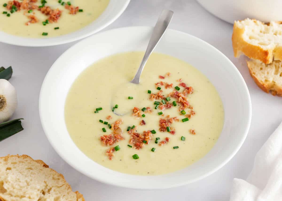 Potato leek soup in a white bowl.