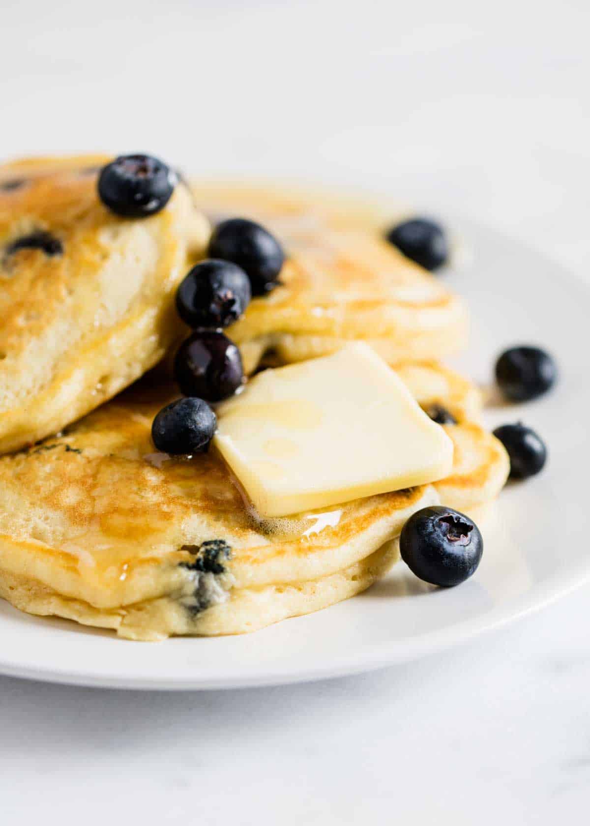 Blueberry pancakes on a white plate.
