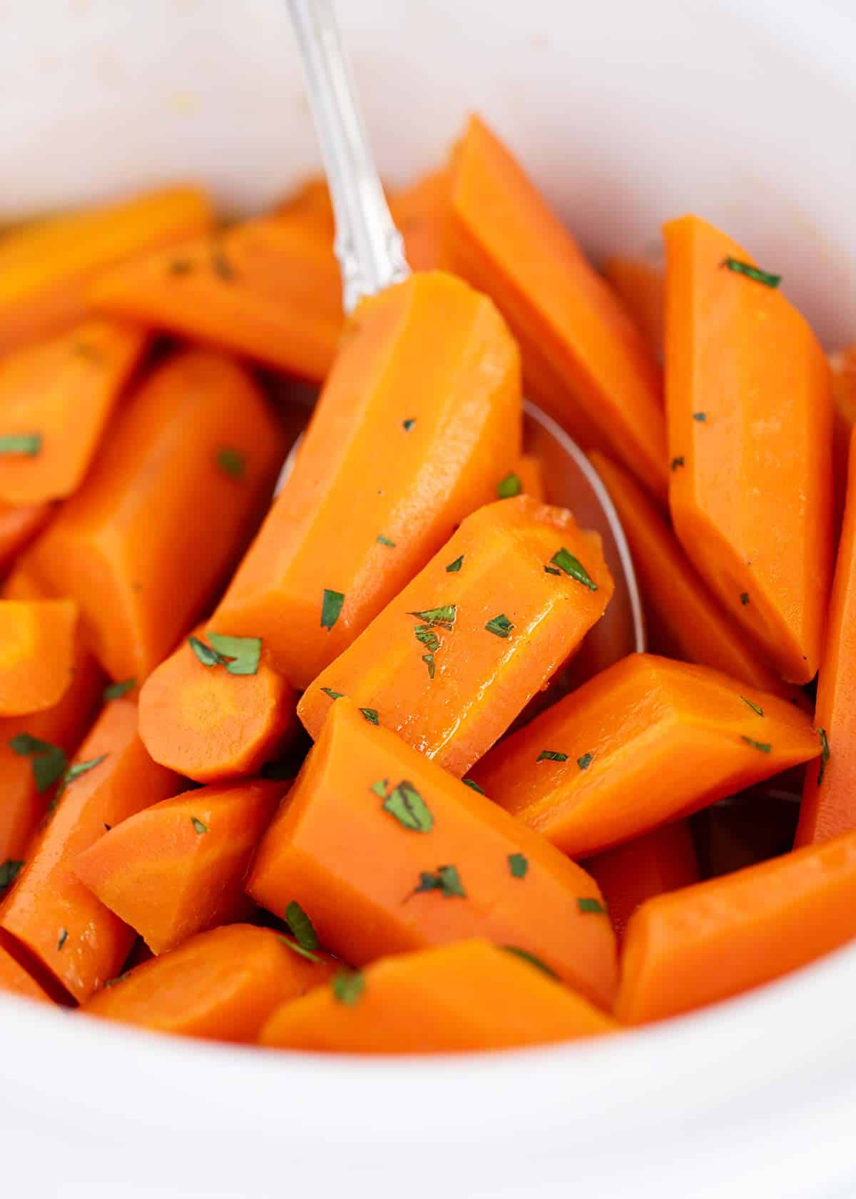 Brown sugar carrots in a white bowl.