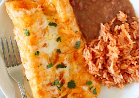 Cheese enchiladas with rice and beans on a plate.