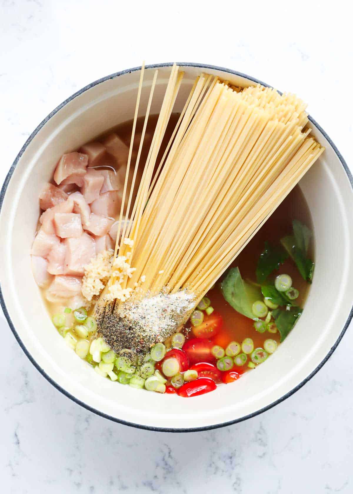 A pot full of all the ingredients for the caprese chicken pasta. 