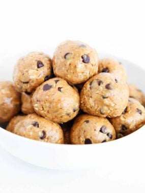 Energy balls stacked in a white bowl.