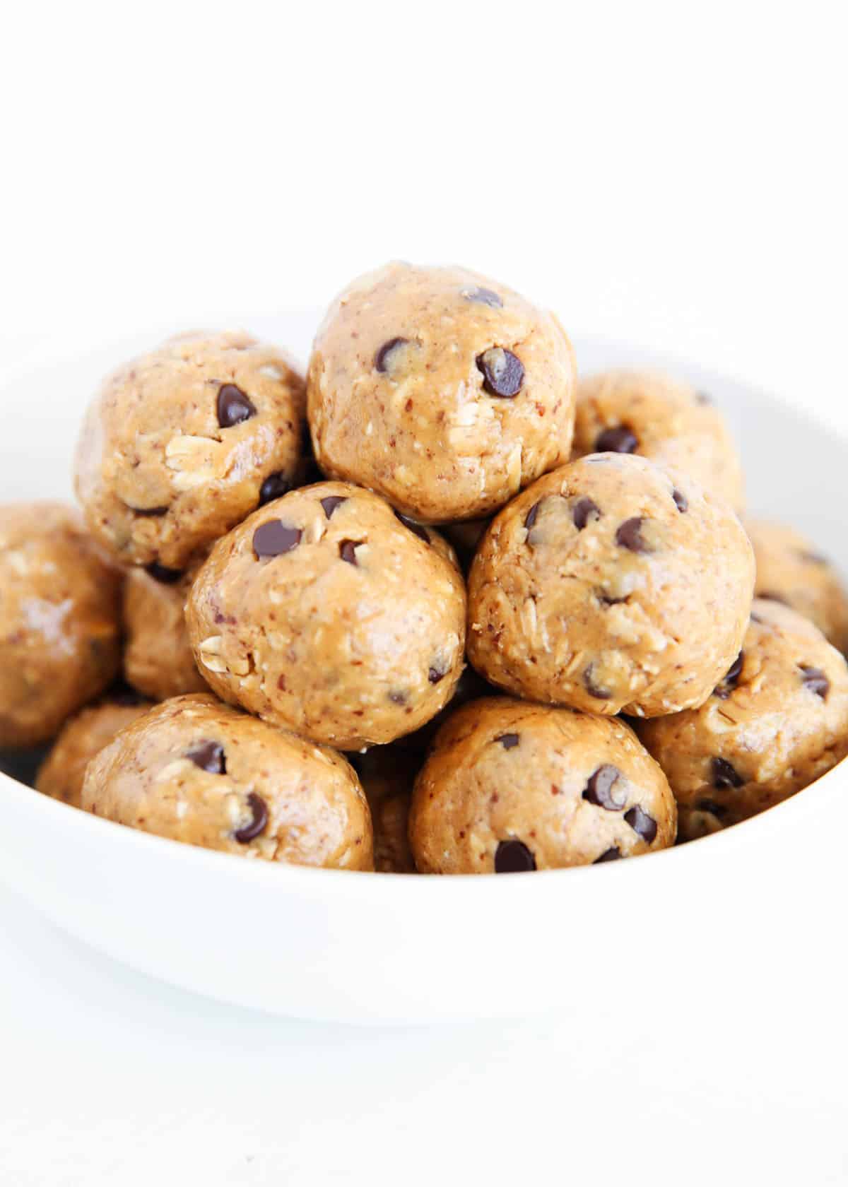Energy balls stacked in a white bowl.
