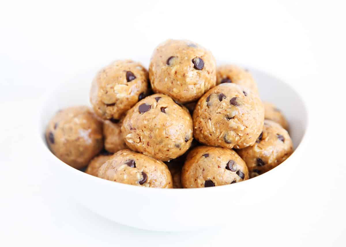 No-bake energy balls recipe are the perfect breakfast or portable snack loaded with good for you ingredients. Made in one bowl in only 5 minutes with 5 ingredients! Homemade no-bake energy balls stacked in a bowl for an easy bite-sized snack.