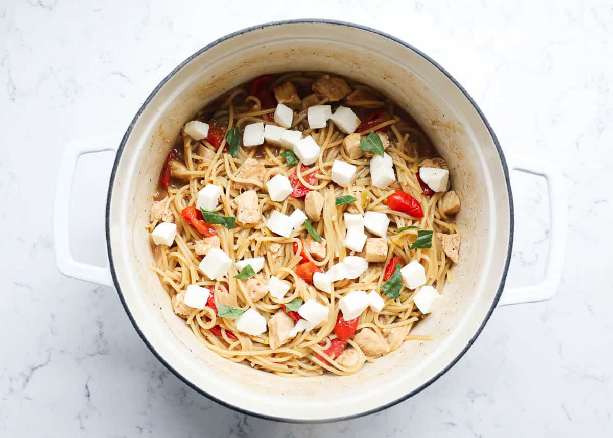 An overhead photo of caprese chicken pasta in a large pot. 