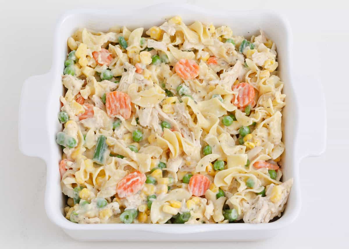 Chicken, egg noodles and veggies in a baking dish.