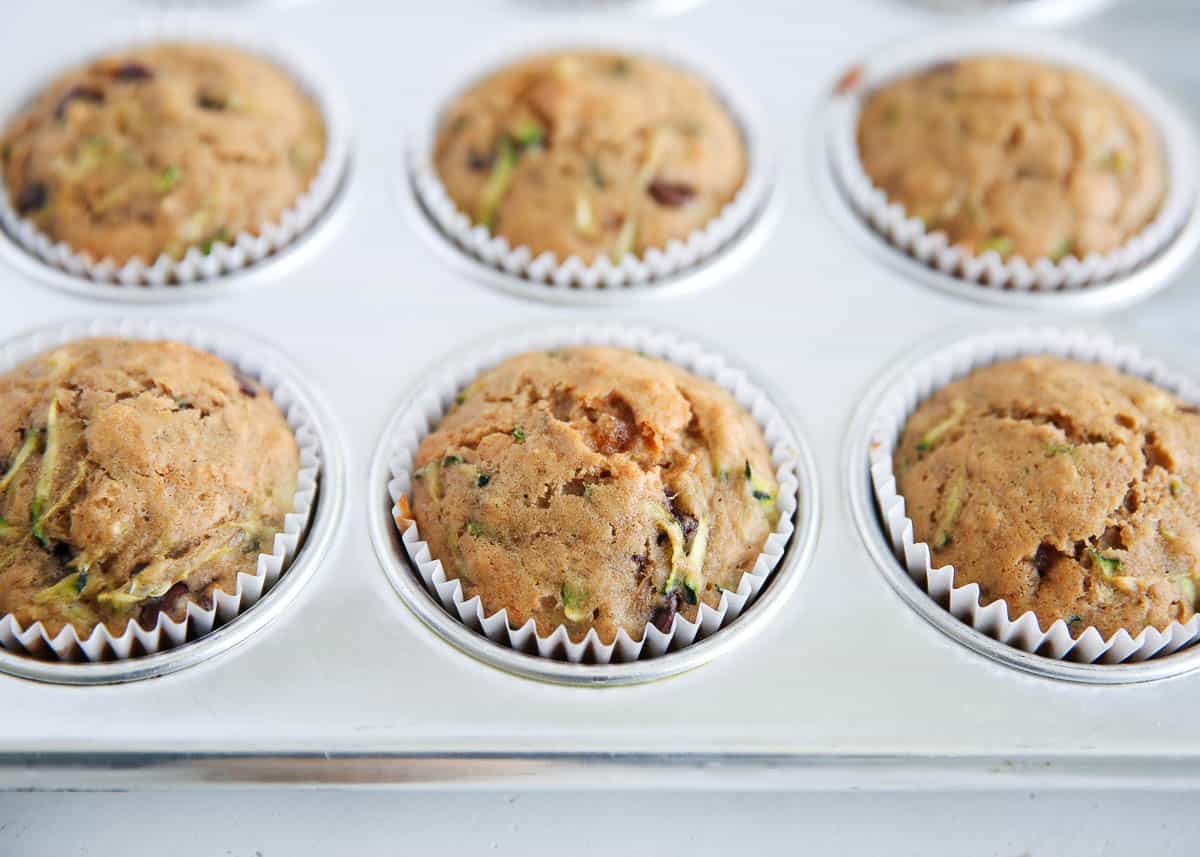 Overhead shot of golden zucchini muffins baked in a muffin tin