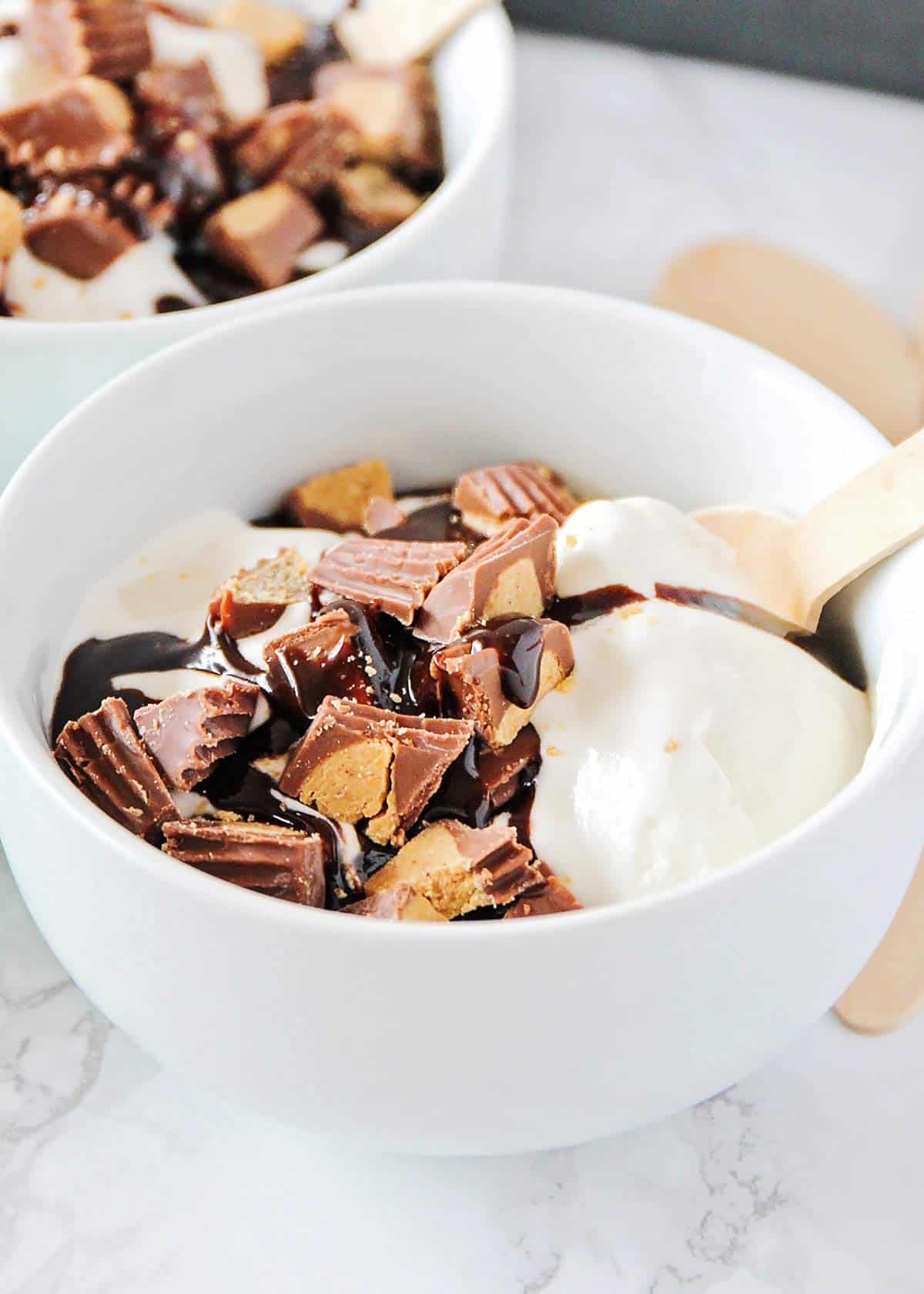 A white bowl with Reese's ice cream in it. 