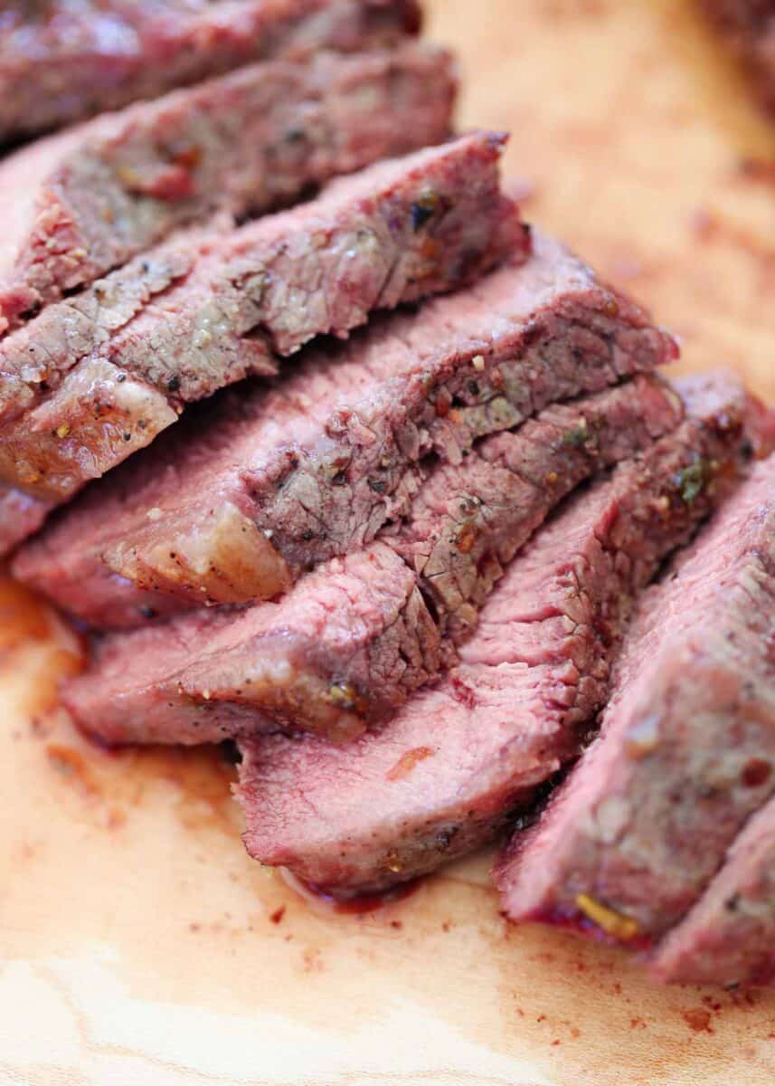 Sliced sirloin steak on a cutting board.