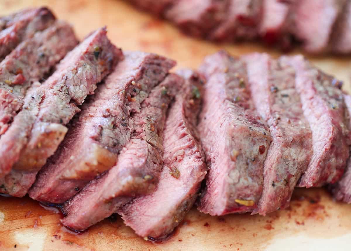 Sliced sirloin steak on a cutting board.