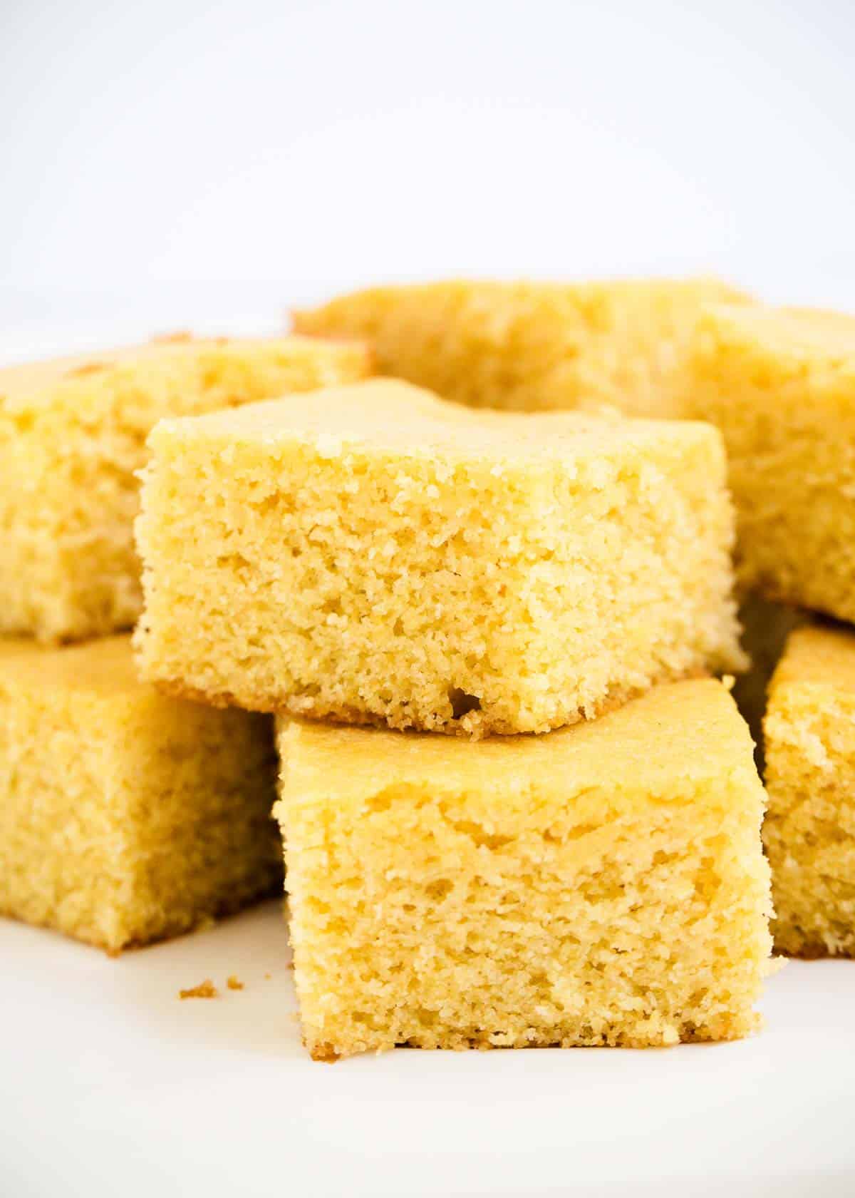 Stacked cornbread on a white plate. 