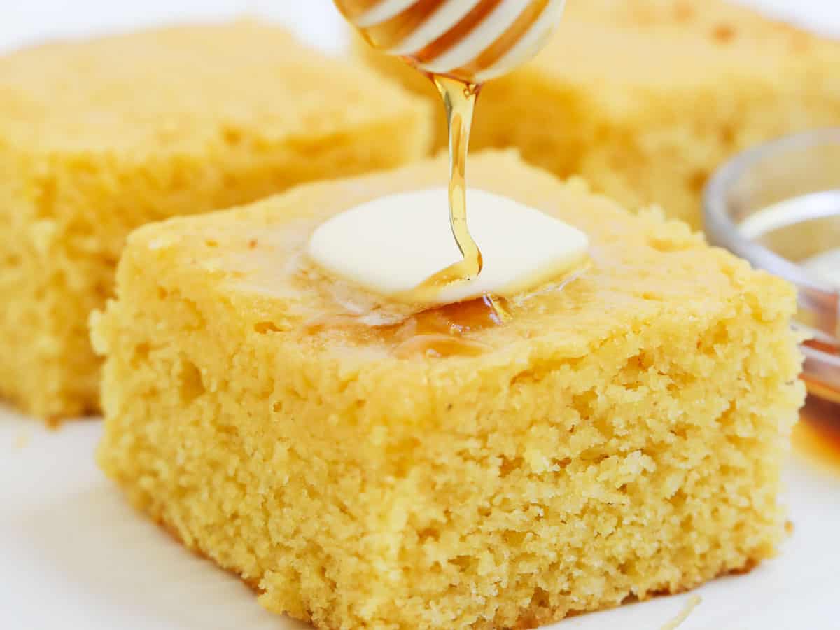 This sweet cornbread is one of my favorites to make during the fall. It's super moist, fluffy and pairs perfectly with a hot bowl of chili. Cornbread with honey and butter on top.