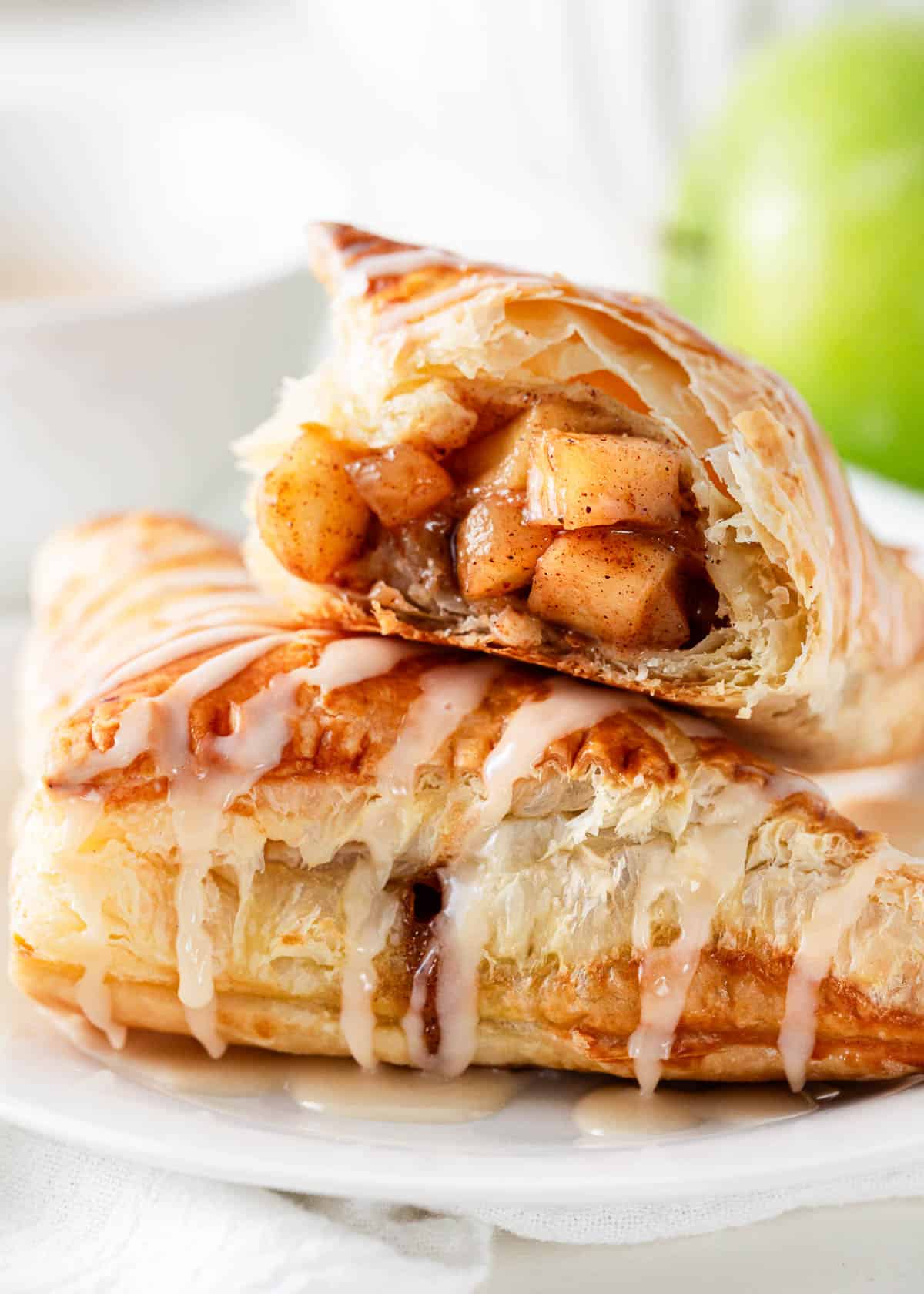 Stacked apple turnover on a plate.