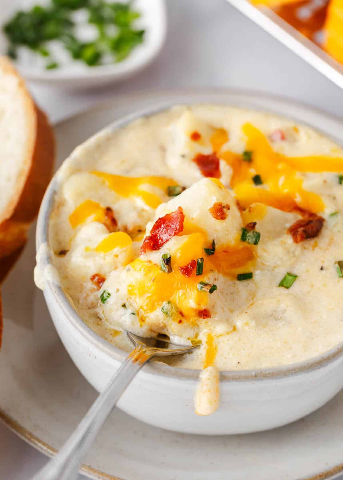 Baked potato soup in a white bowl.