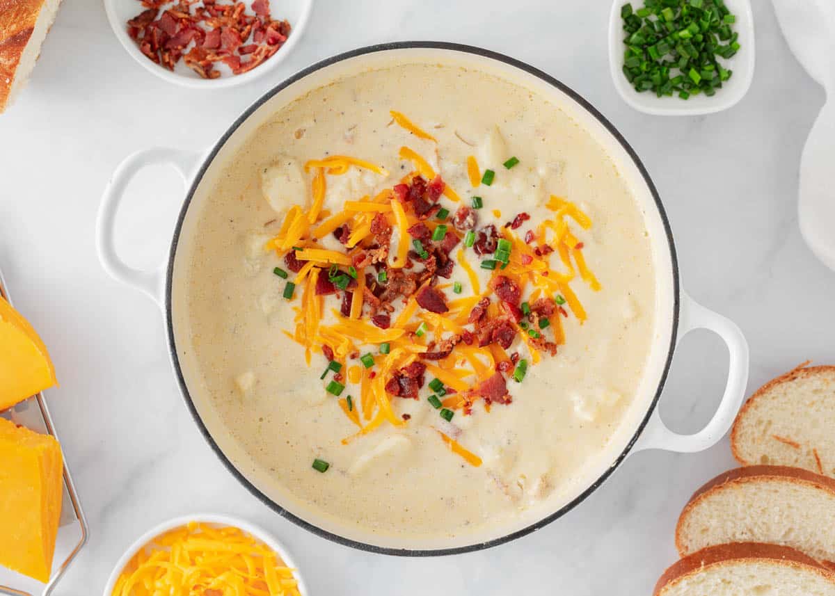 Baked potato soup cooked in a white pot.