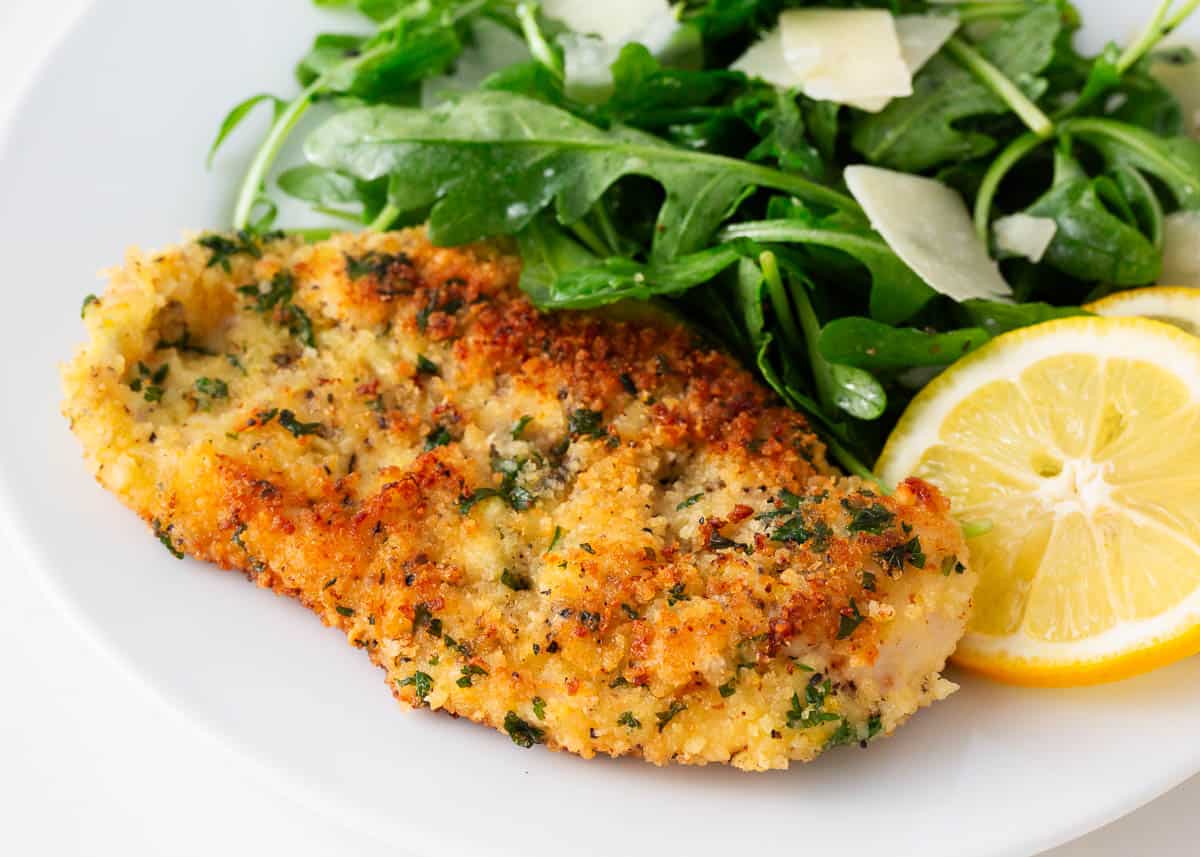 Chicken milanese on a white plate.