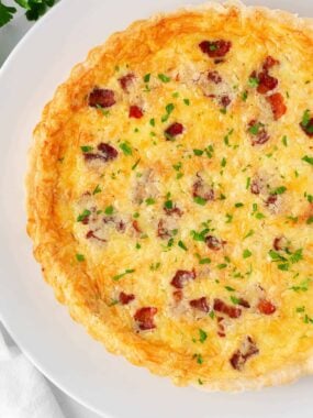 Quiche lorraine on a white plate.