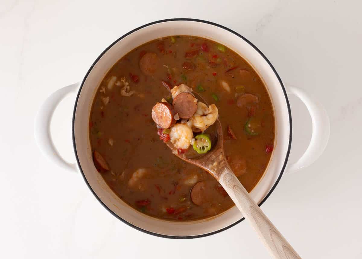 New Orleans gumbo simmering on in a white pot.