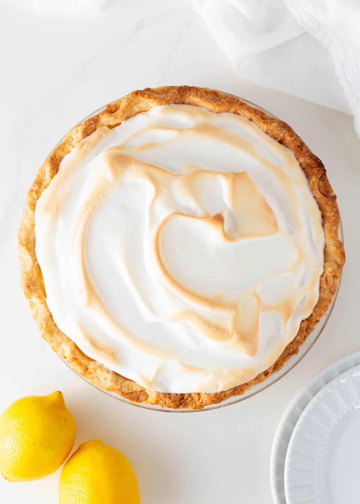 Lemon meringue pie in a glass pie dish.