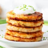 Stacked mashed potato pancakes on a plate.
