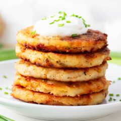 Stacked mashed potato pancakes on a plate.