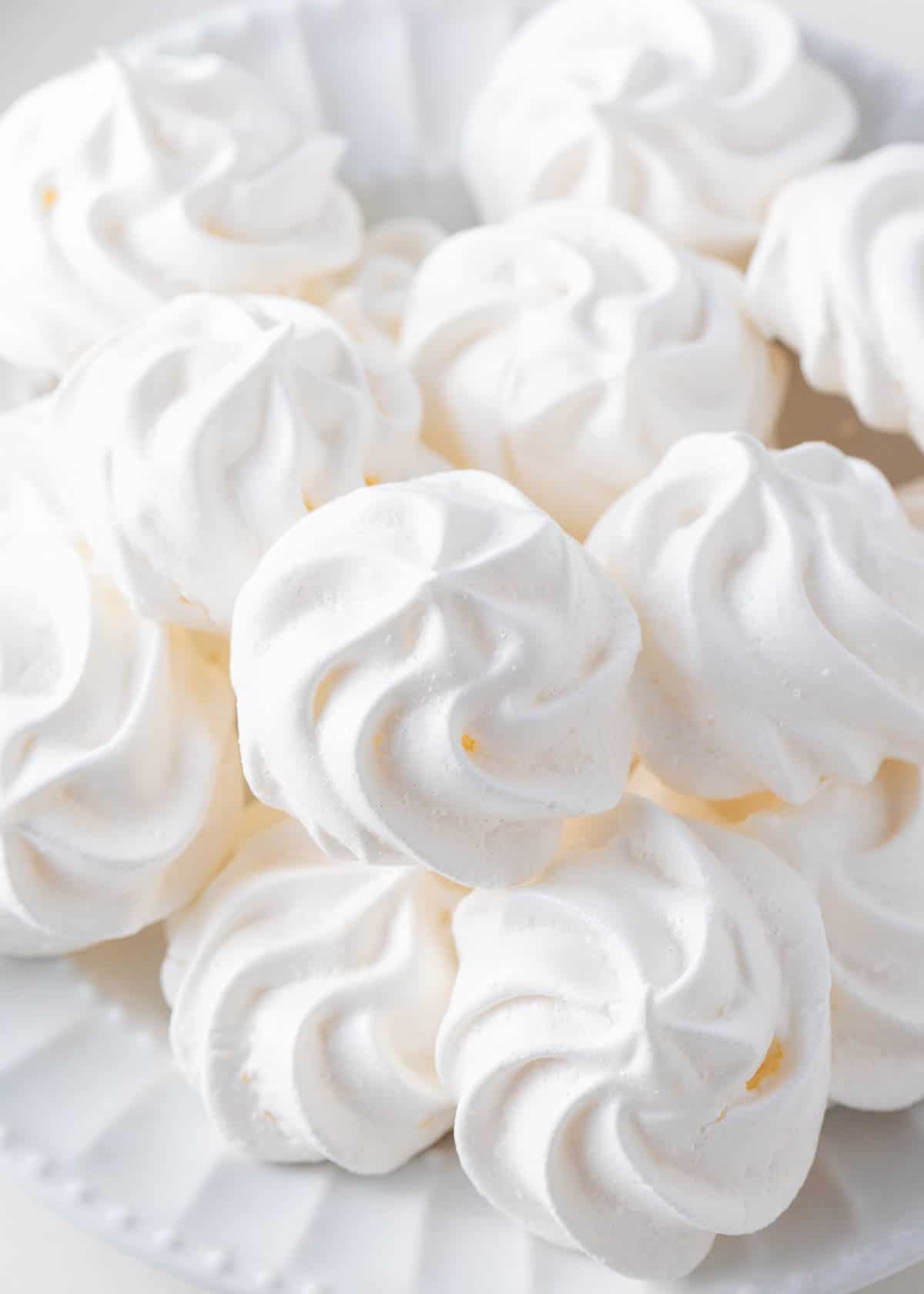 Meringue cookies stacked on a plate.