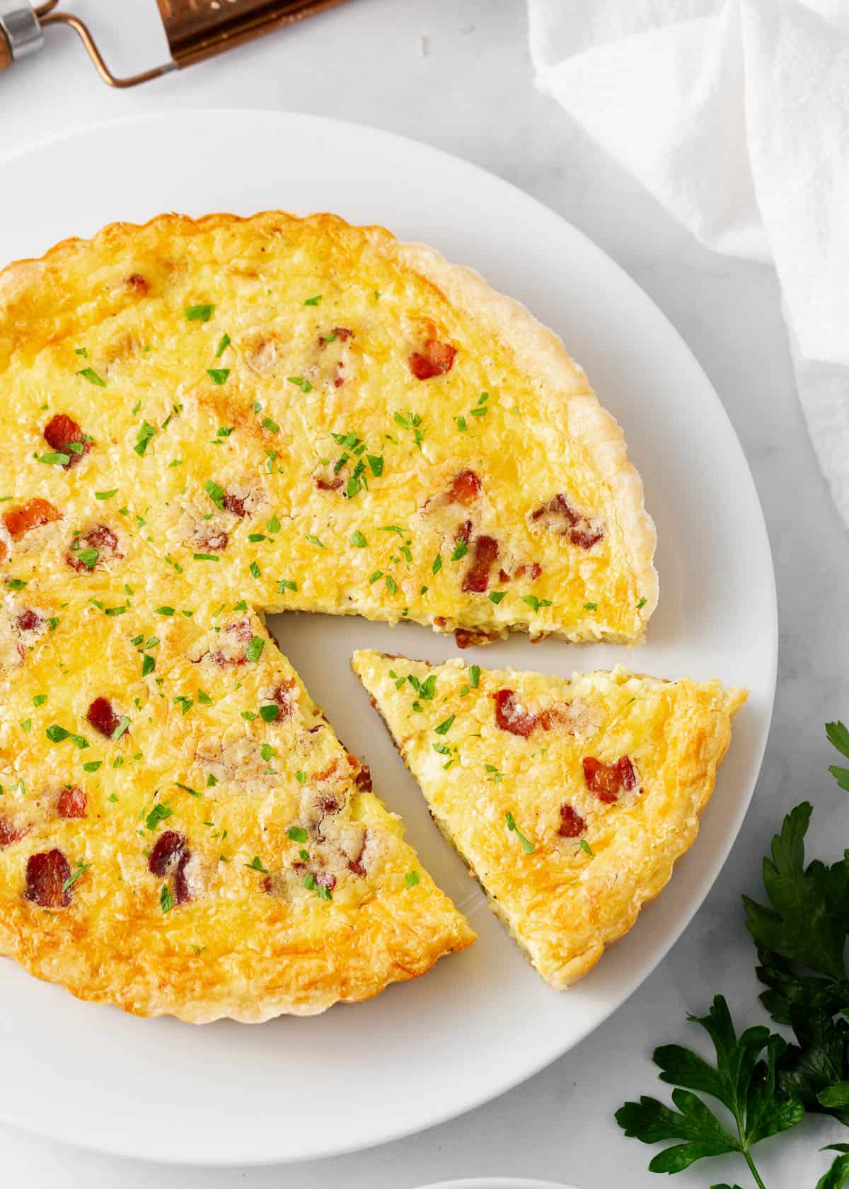 Quiche lorraine on a white plate.