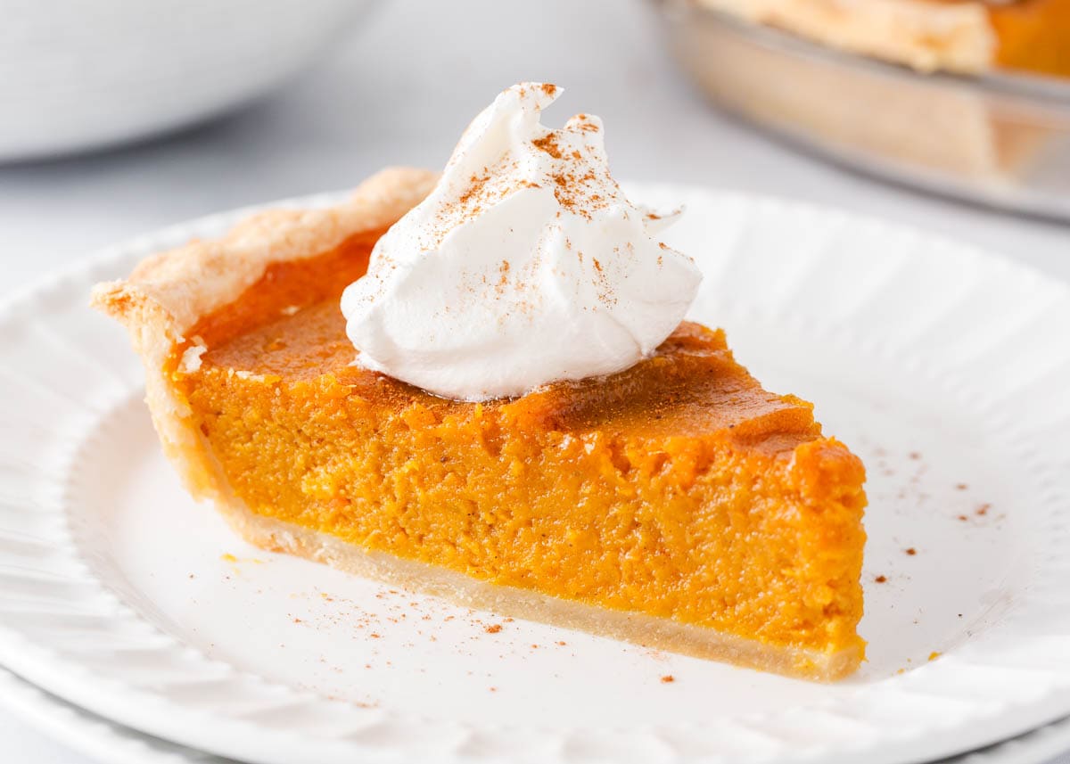 Slice of sweet potato pie on a white plate. 