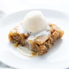 Apple cake with ice cream on a white plate.