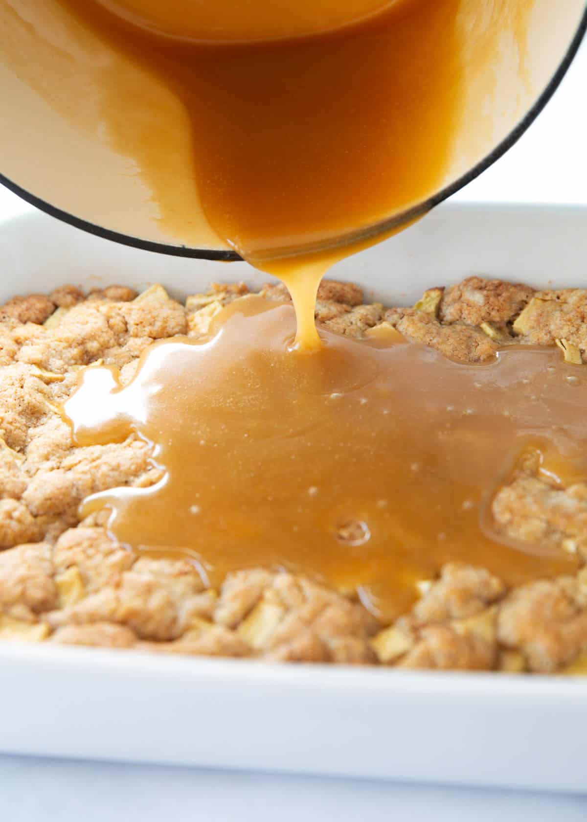 Pouring glaze onto an apple cake.