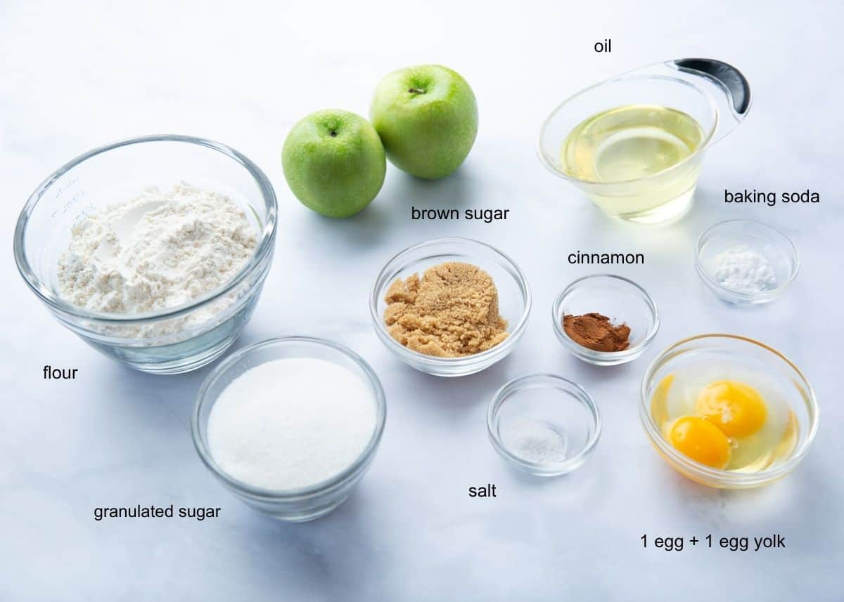 This easy apple cake is a moist, simple cake full of warm cinnamon spice and loaded with fresh apples! Drizzled with a buttery caramel sauce, it's one of the best autumn treats! Ingredients for fresh apple cake with caramel glaze including Granny Smith apples, flour, granulated and brown sugar, oil, eggs, cinnamon, baking soda, and salt.