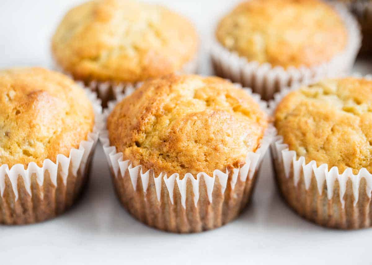 These easy banana bread muffins are the best for breakfast or an afternoon snack! Made in one bowl in 30 minutes they will be your go-to recipe for soft and moist muffins. Banana bread muffins lined up together on the counter.