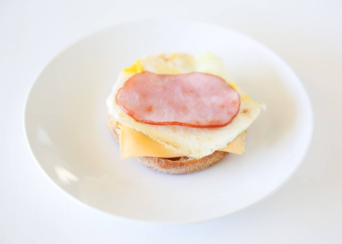 Breakfast sandwich on a white plate. 