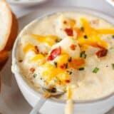 Baked potato soup in a white bowl.