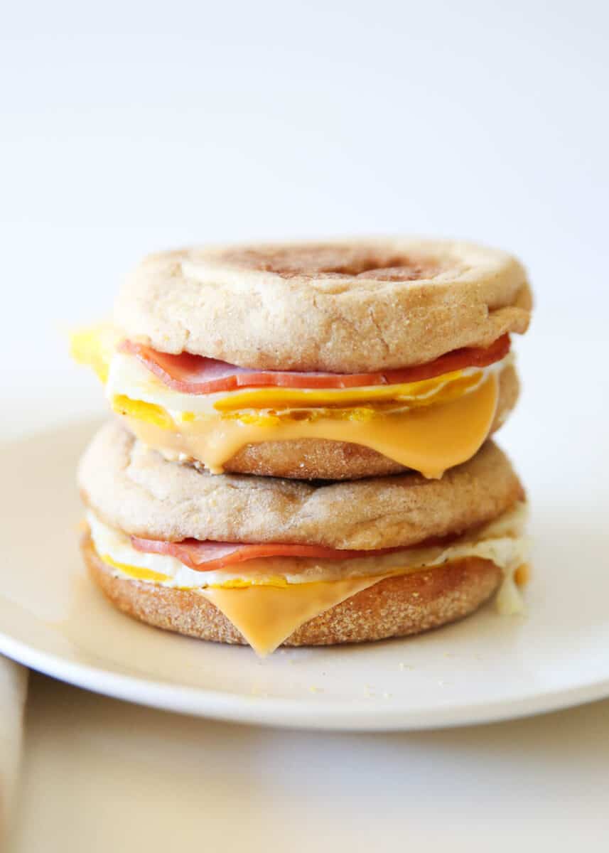 Two egg mcmuffins stacked on a plate. Easy breakfast hack ready in 15 minutes or make ahead and freeze.