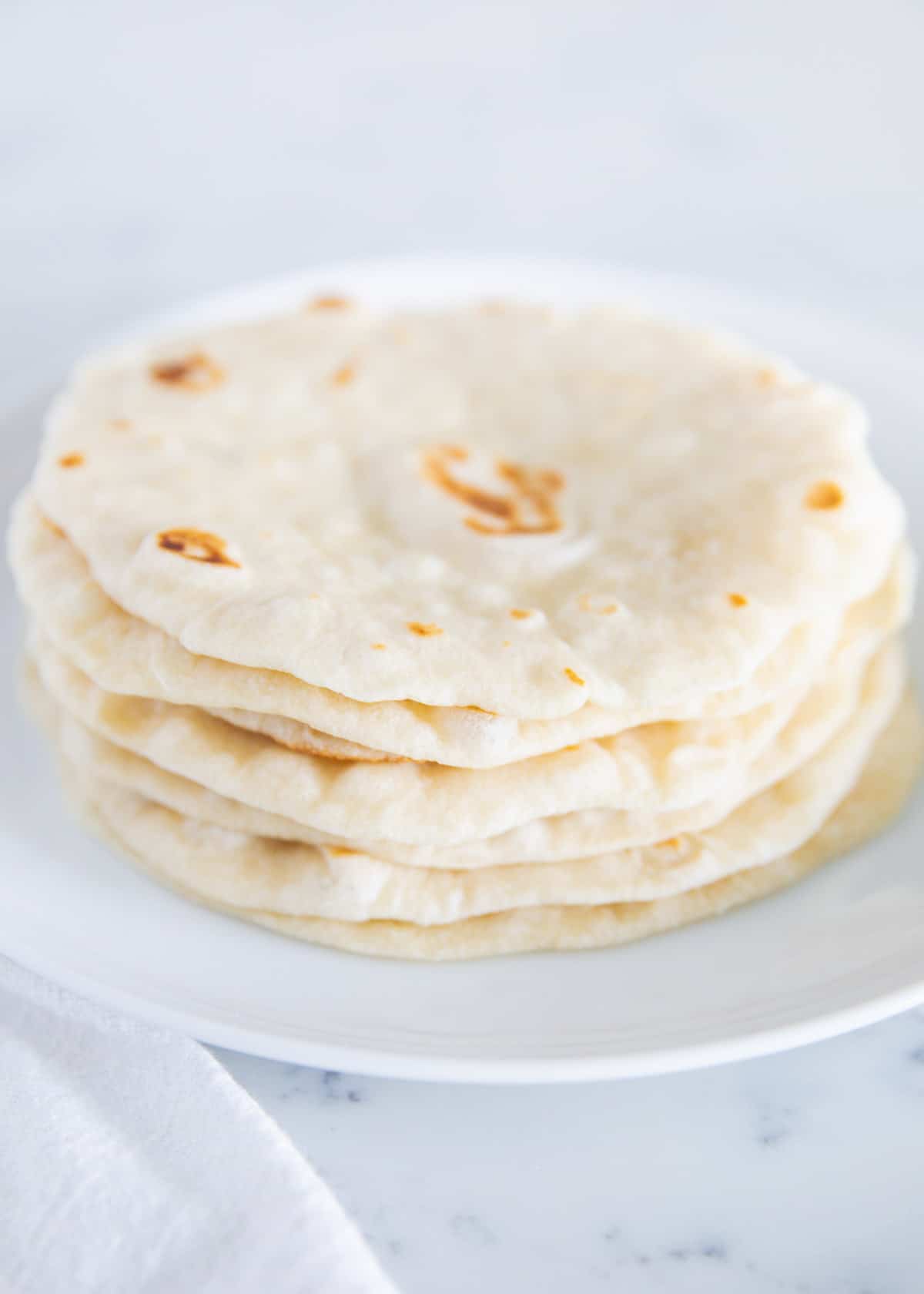 Homemade flour tortillas perfectly stacked on top of each other. 
