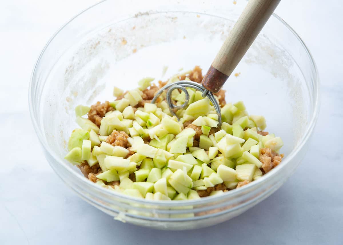 Apple cake ingredients in a bowl.