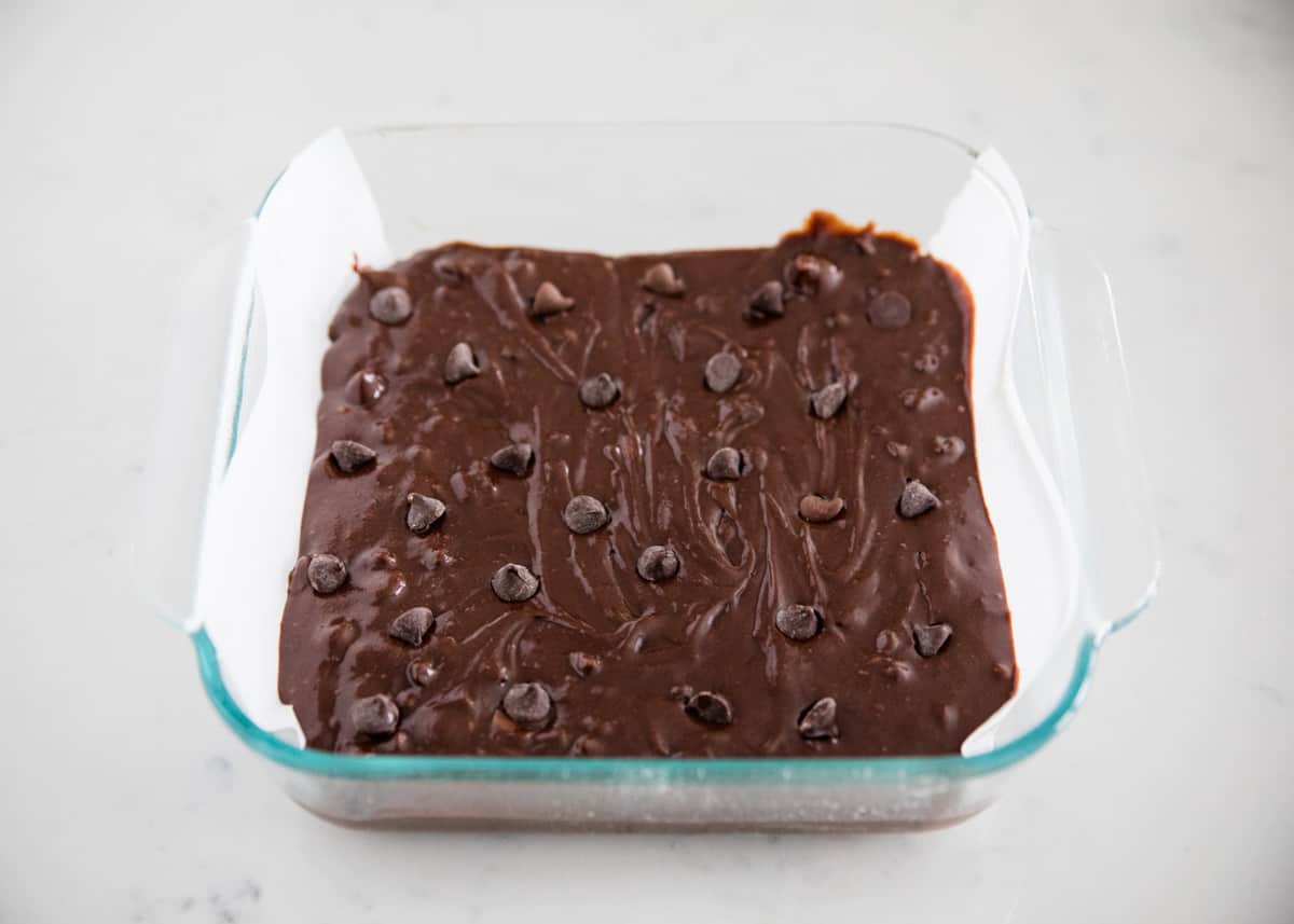 Brownie batter in a glass baking pan. 
