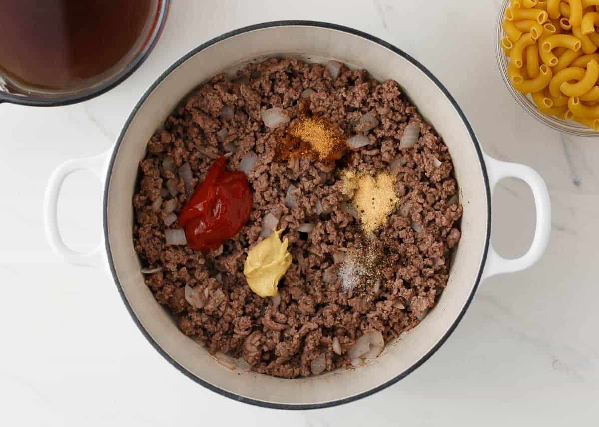 Ground beef cooked with onions and seasonings in a white pot for homemade hamburger helper.