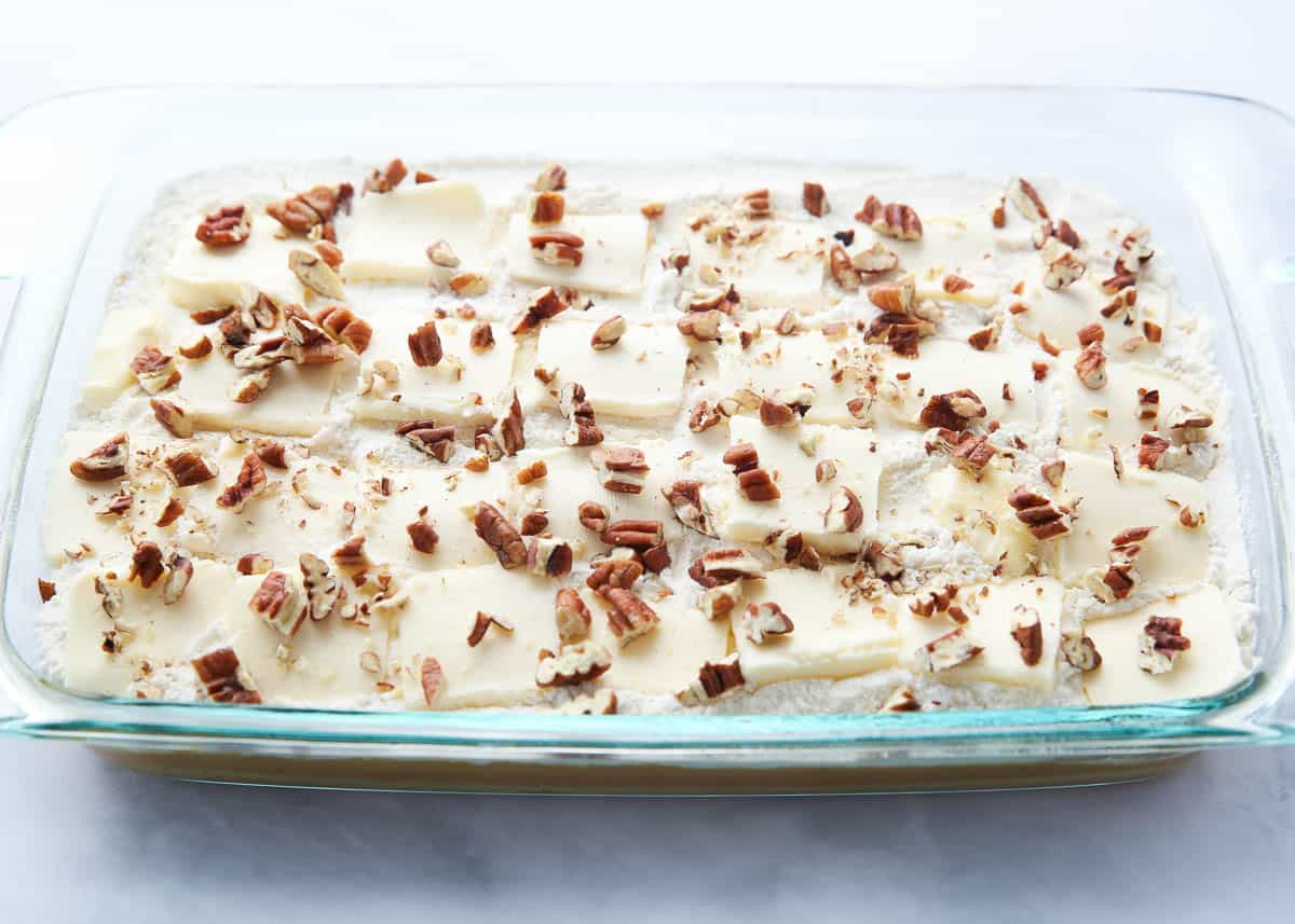 Showing how to make pumpkin dump cake in a glass dish.