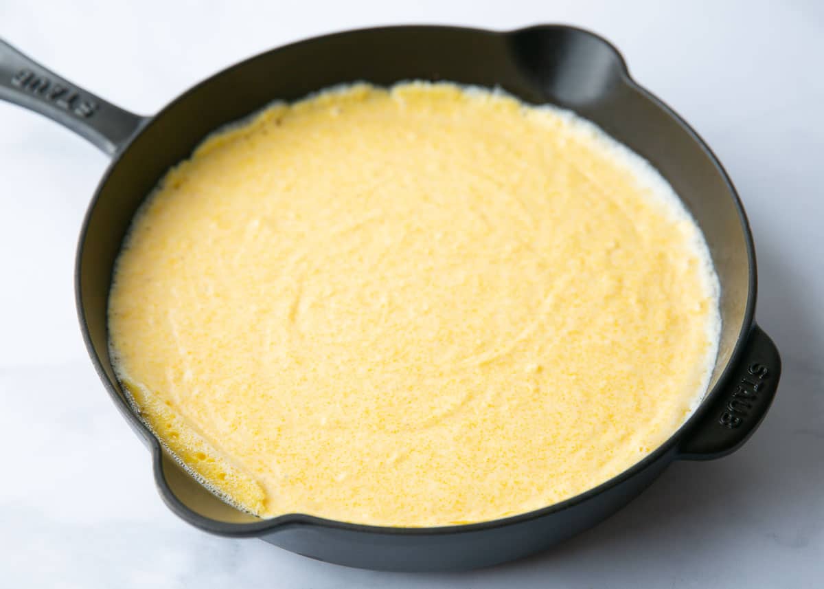 Cornbread batter in a cast iron skillet.