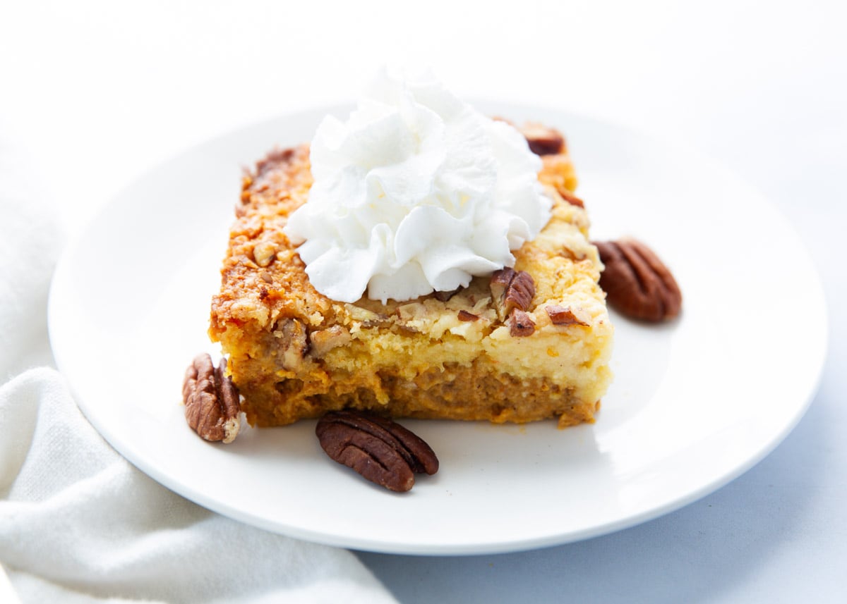 Slice of pumpkin dump cake on a white plate.