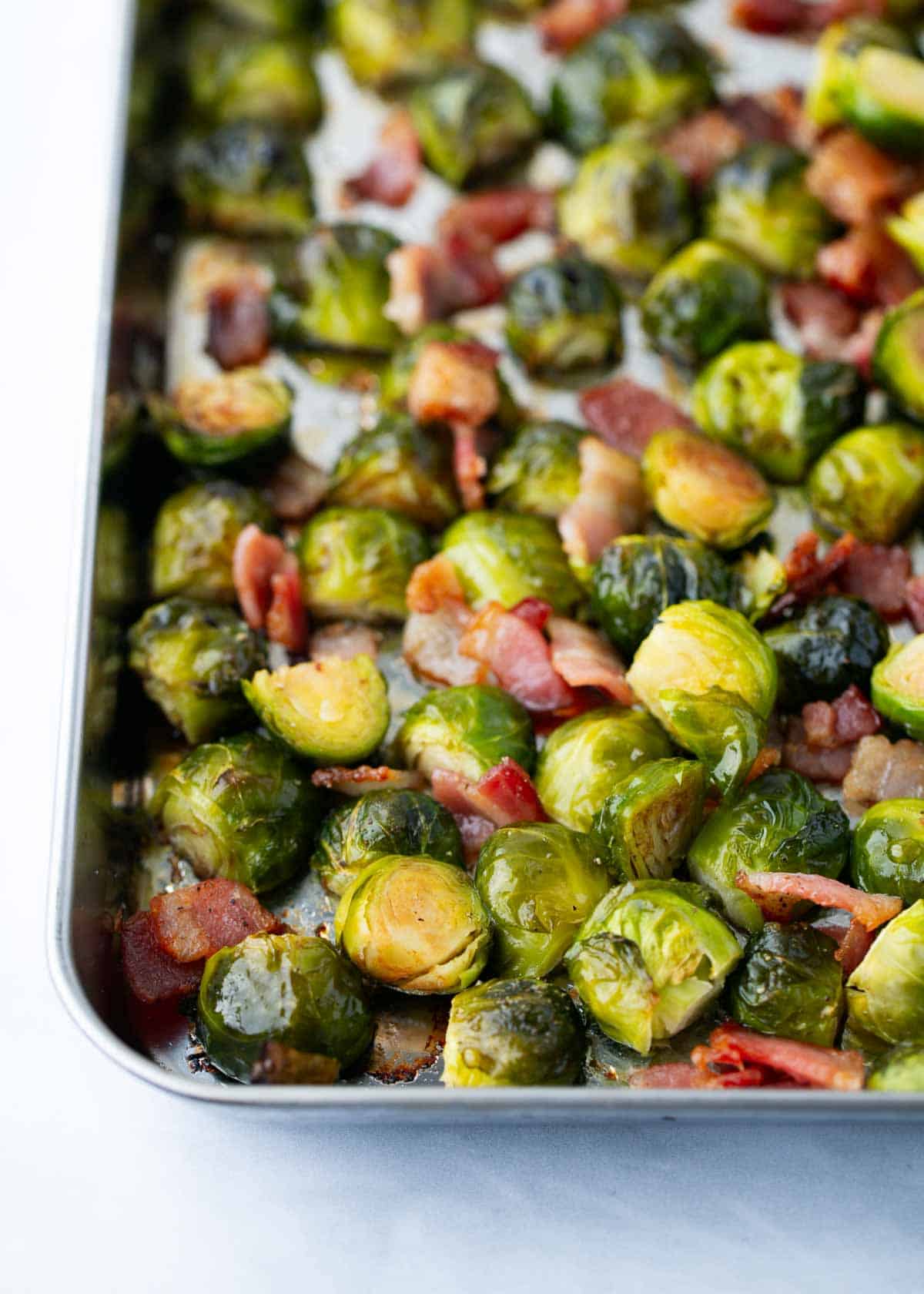 Roasted brussels sprouts with bacon in a pan.