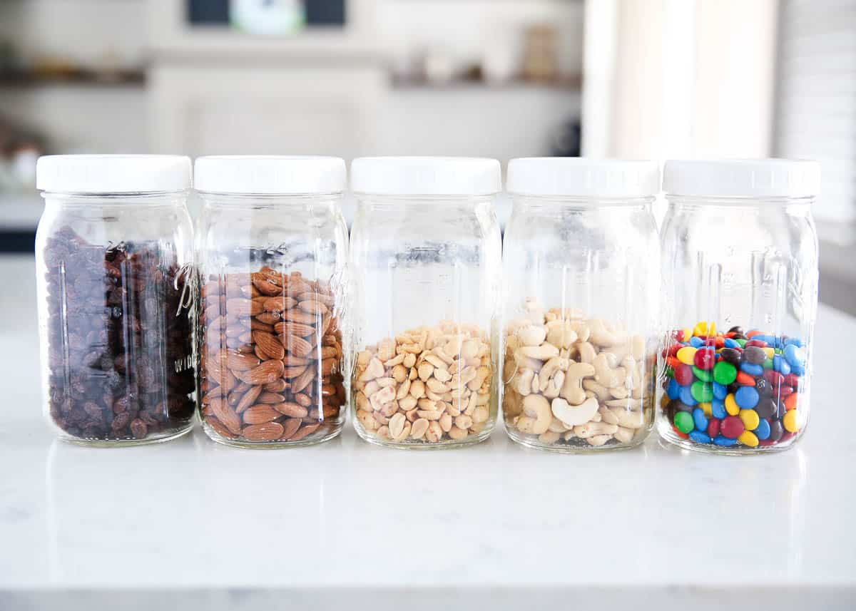 Jars full of individual ingredients in trail mix.  